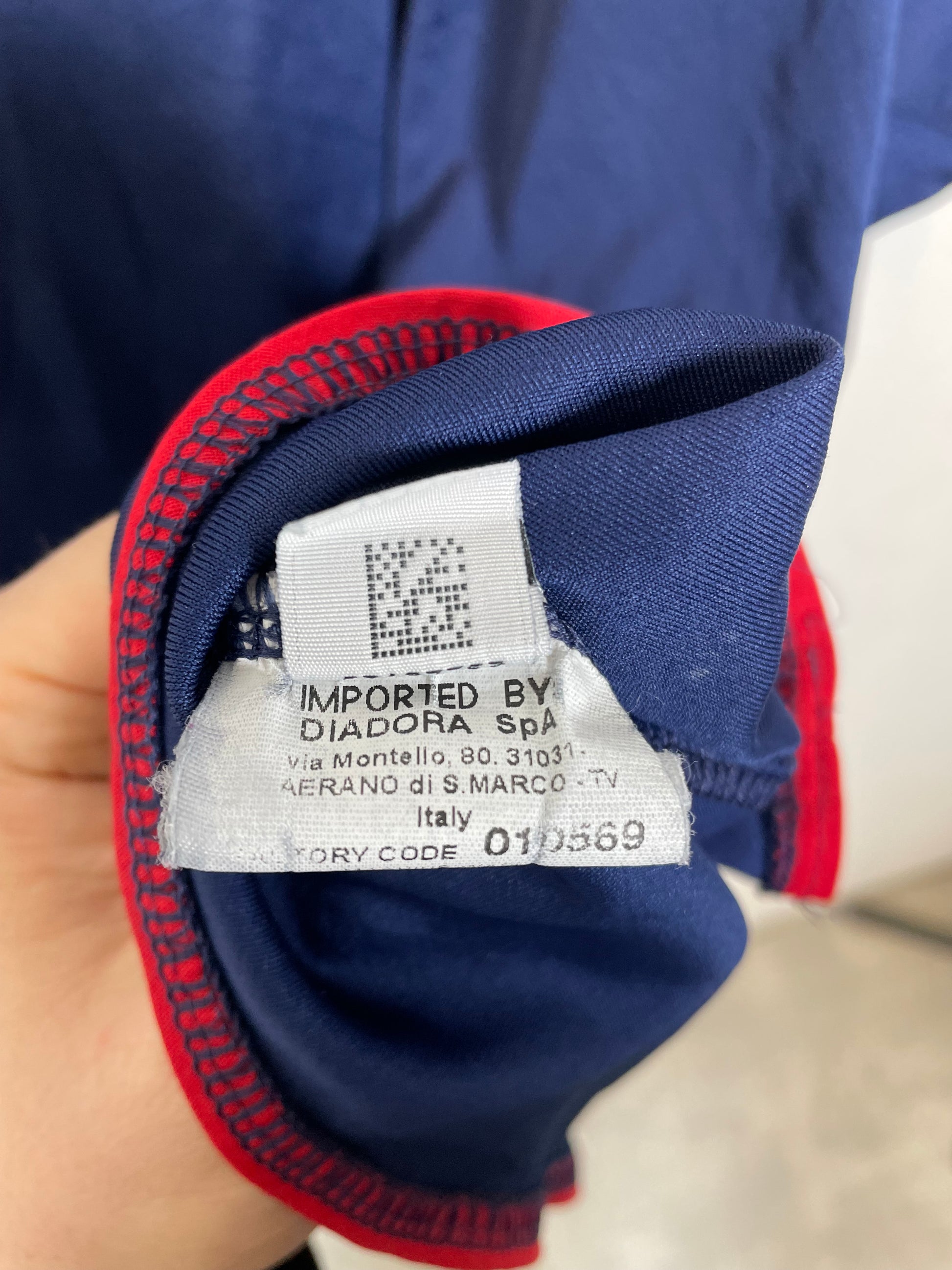 Close-up of a clothing tag on a blue and red garment