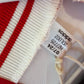 Close-up of Ajax Amsterdam club badge and Adidas three stripes logo on white 2023/24 home jersey
