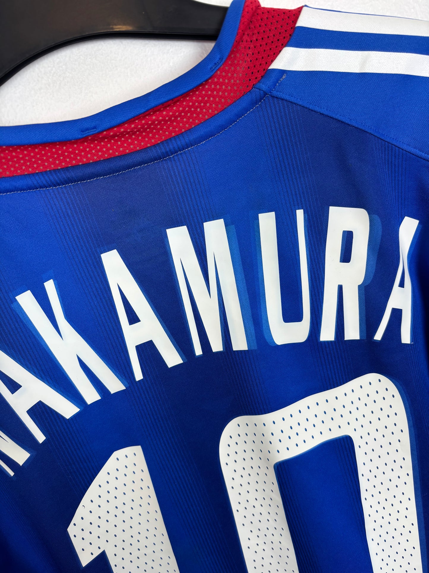 Close-up of Adidas trefoil logo and Japan Football Association crest on 2006 blue home shirt