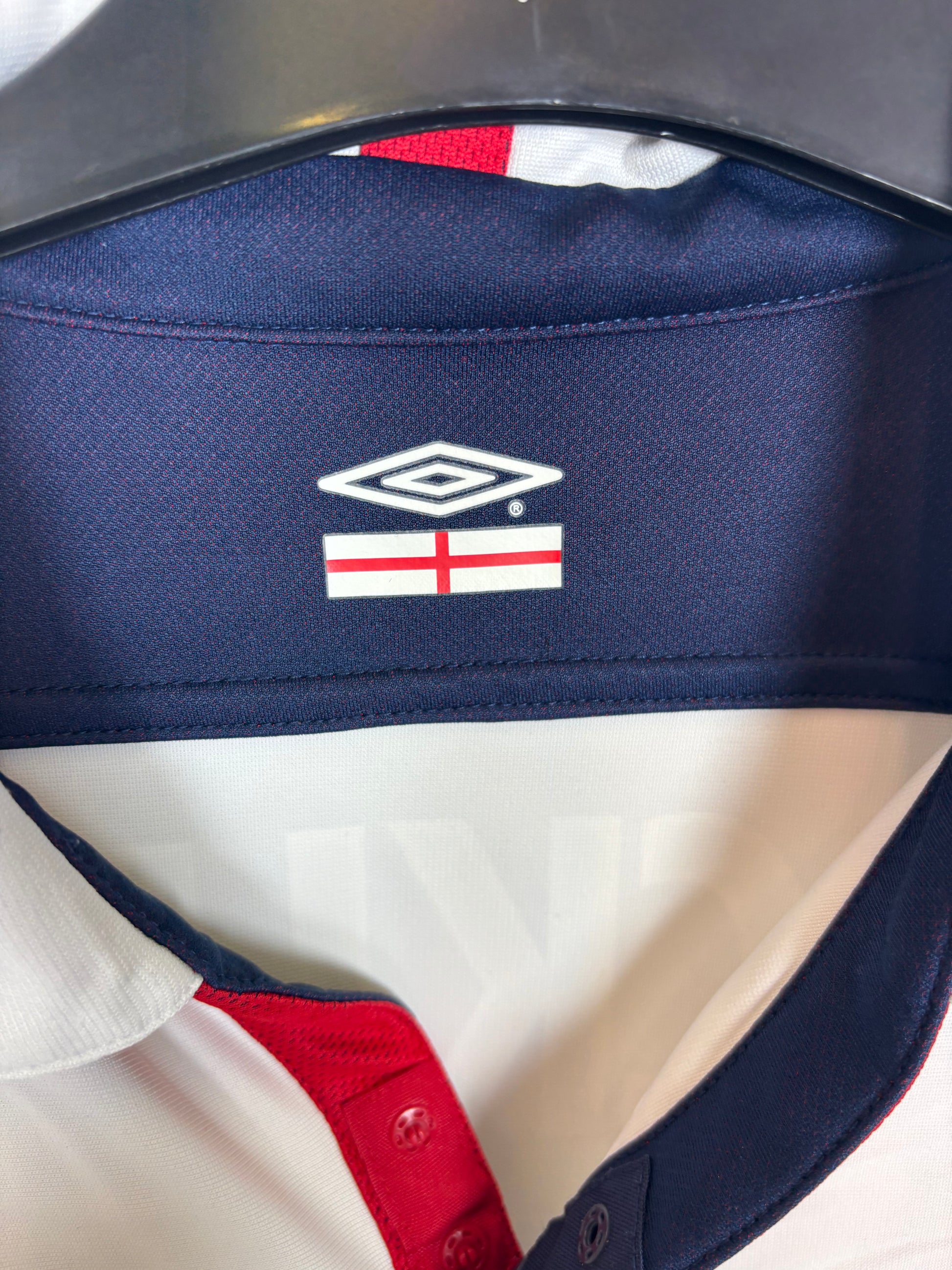 Close-up of Umbro logo and England Three Lions badge on white 03/05 home shirt