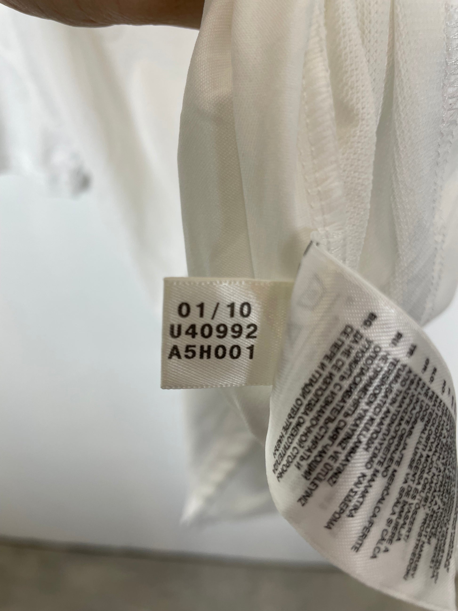 Close-up of a white garment with a label showing text and numbers.