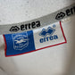 Close-up of Errea logo and Brighton and Hove Albion club badge on 2004/06 home shirt
