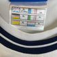 Close-up of England Three Lions crest and Umbro logo on white 99/01 home football shirt collar area