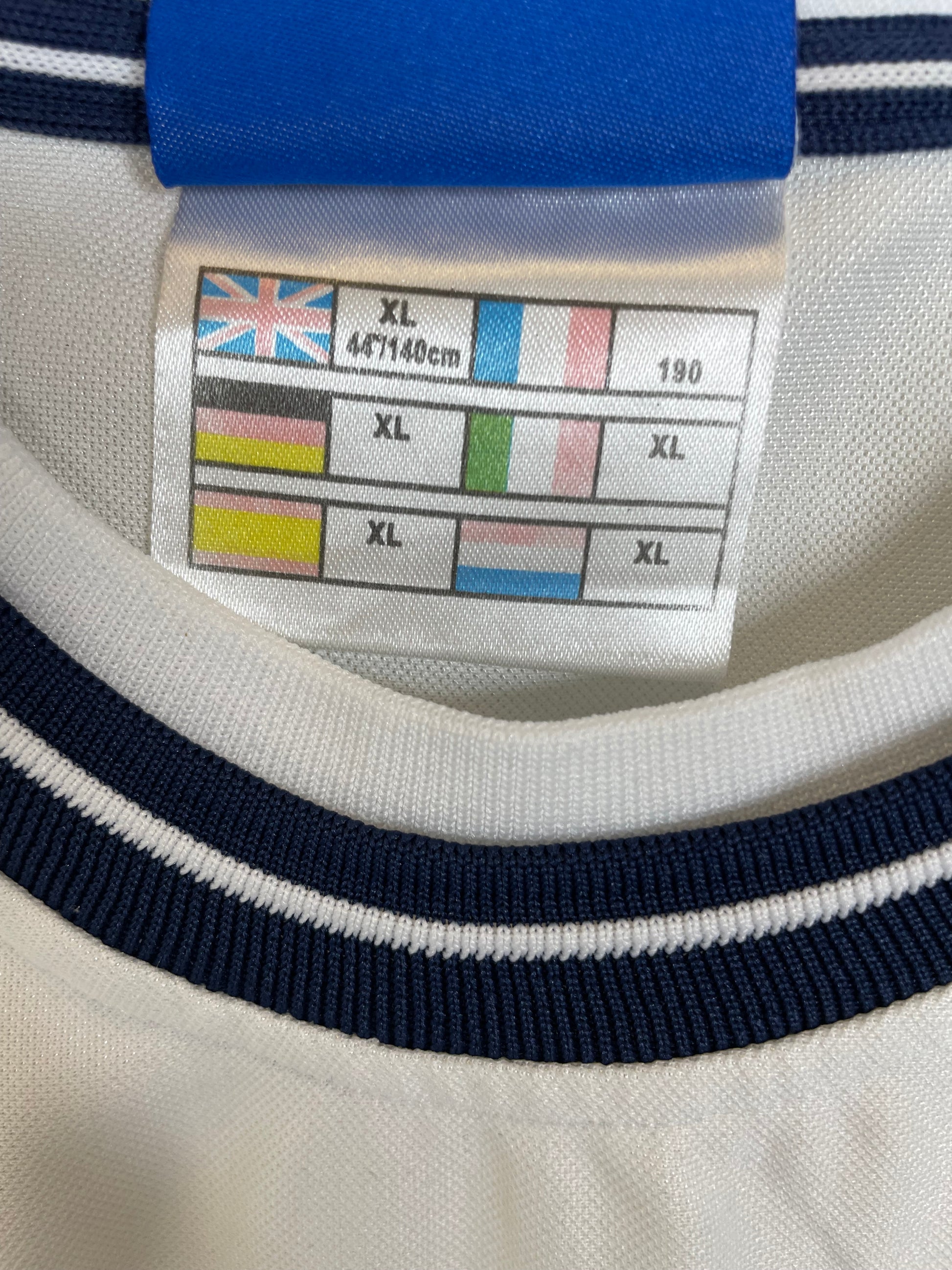 Close-up of England Three Lions crest and Umbro logo on white 99/01 home football shirt collar area