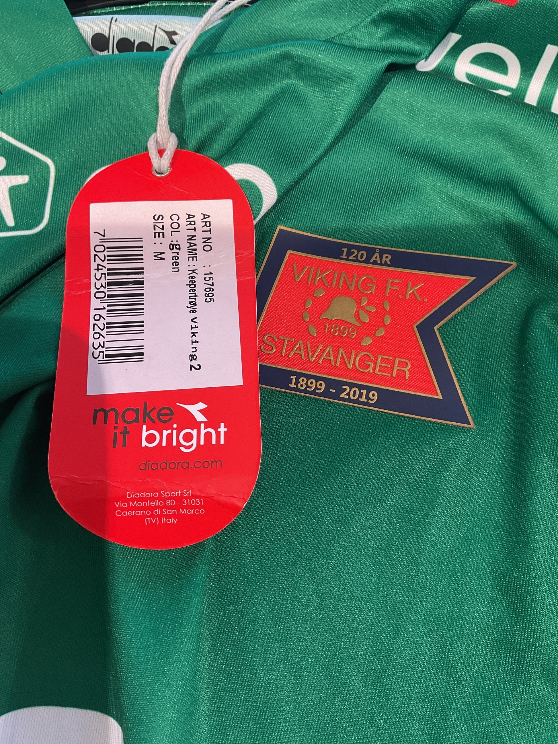 Green sports jersey with a brand tag and logo on a green background