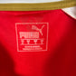 Close-up of Puma logo and Arsenal club badge on red 2015/16 home shirt