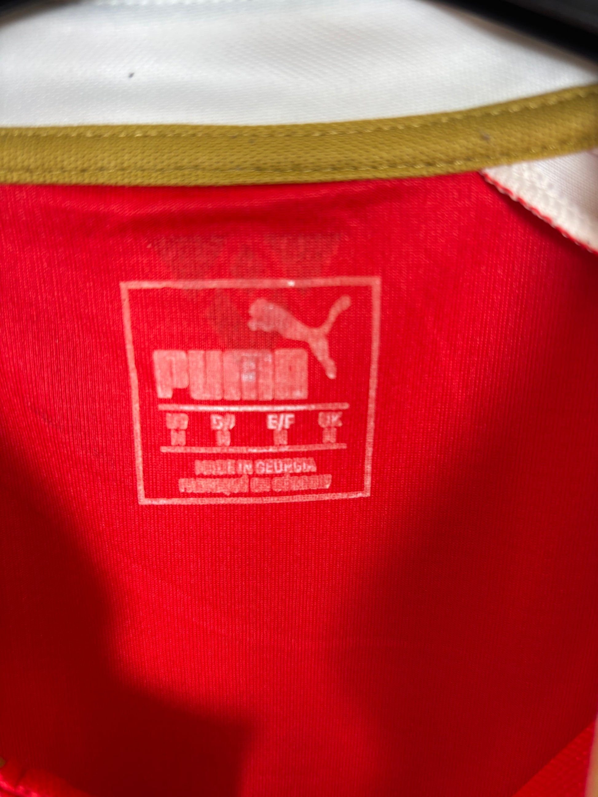 Close-up of Puma logo and Arsenal club badge on red 2015/16 home shirt