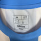 Close-up of Adidas logo and Argentina club badge on light blue home shirt with Messi 10