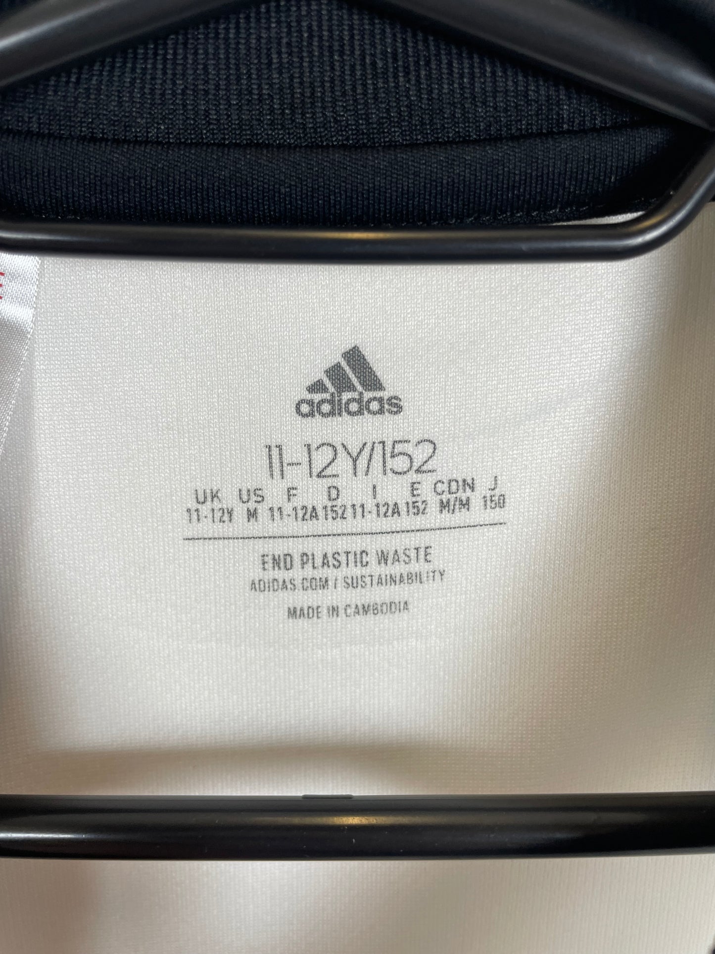Close-up of Adidas three stripes logo and Juventus club crest on kids 22/23 home jersey