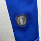Close-up of a blue and white fabric with a circular emblem featuring a flag.