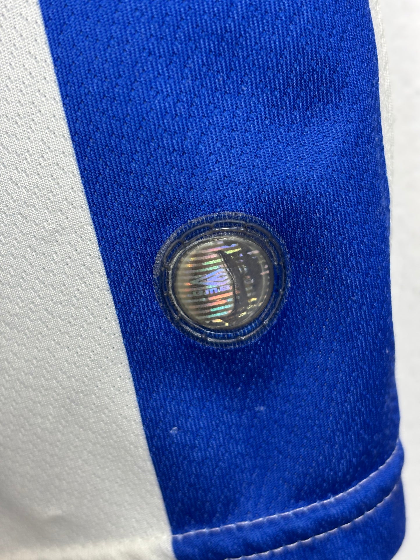 Close-up of a blue and white fabric with a circular emblem featuring a flag.