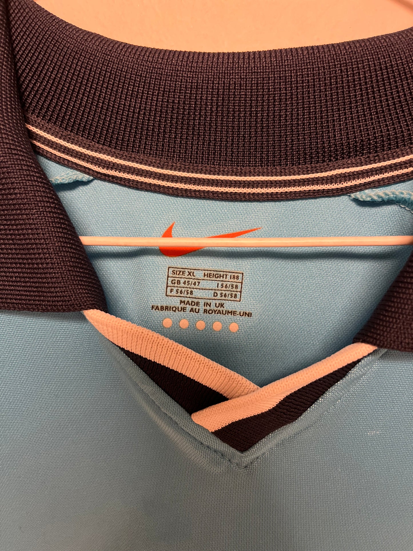 Close-up of a football shirt with a label on a light gray background