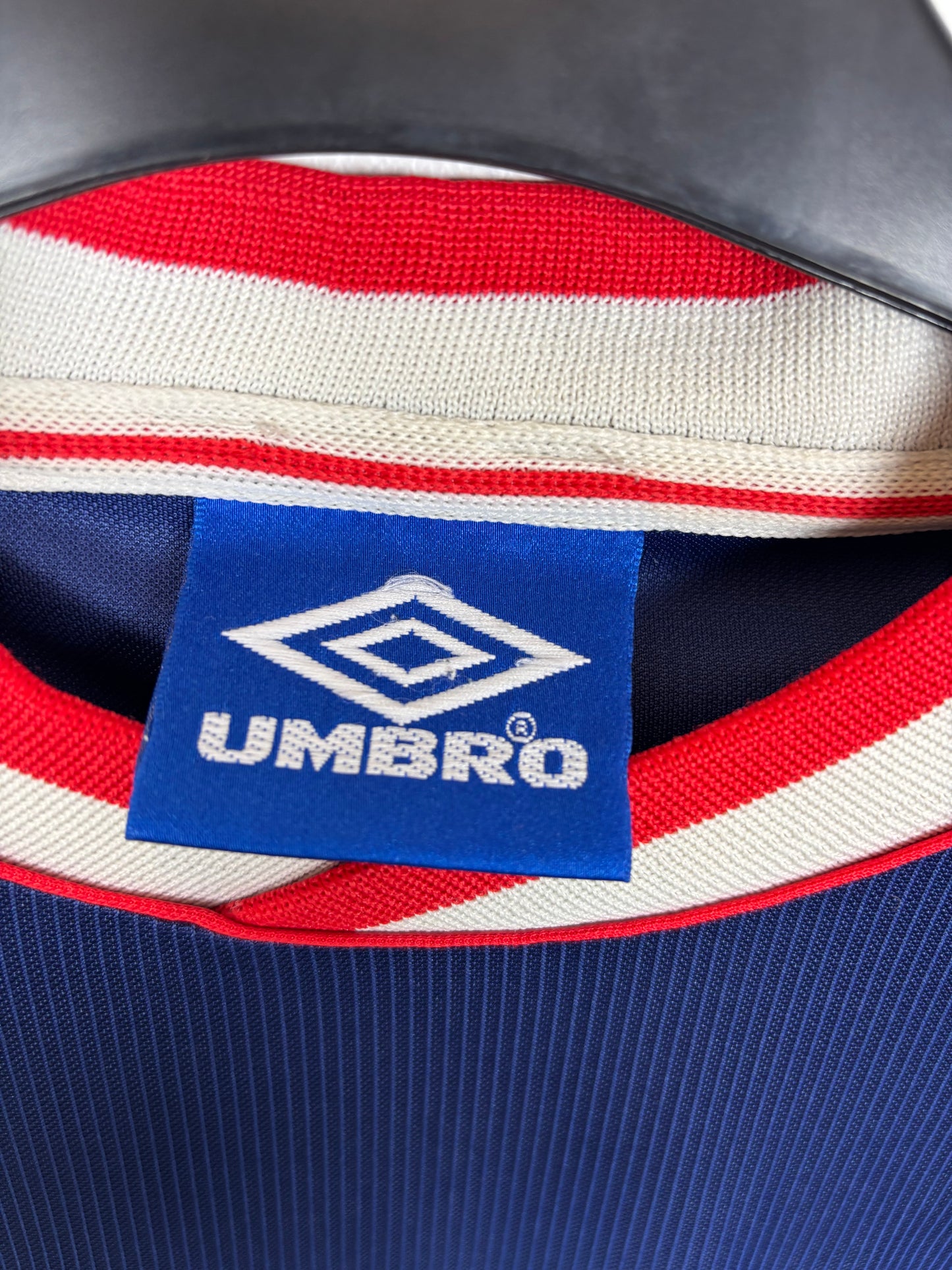 Close-up of Ajax club crest and Umbro logo details on 1999/2000 away football shirt
