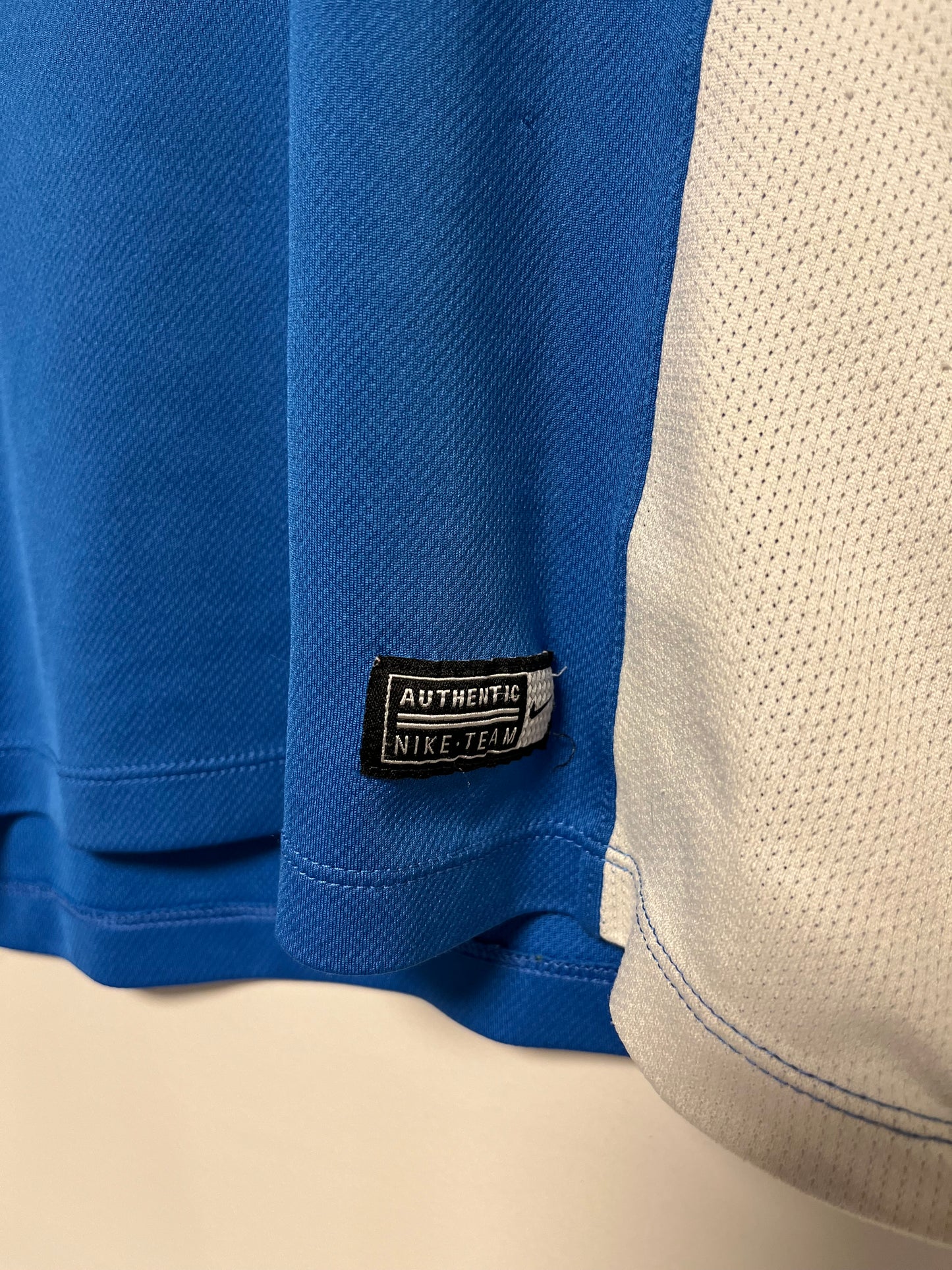 Close-up of a blue shirt with a Nike label on a beige background