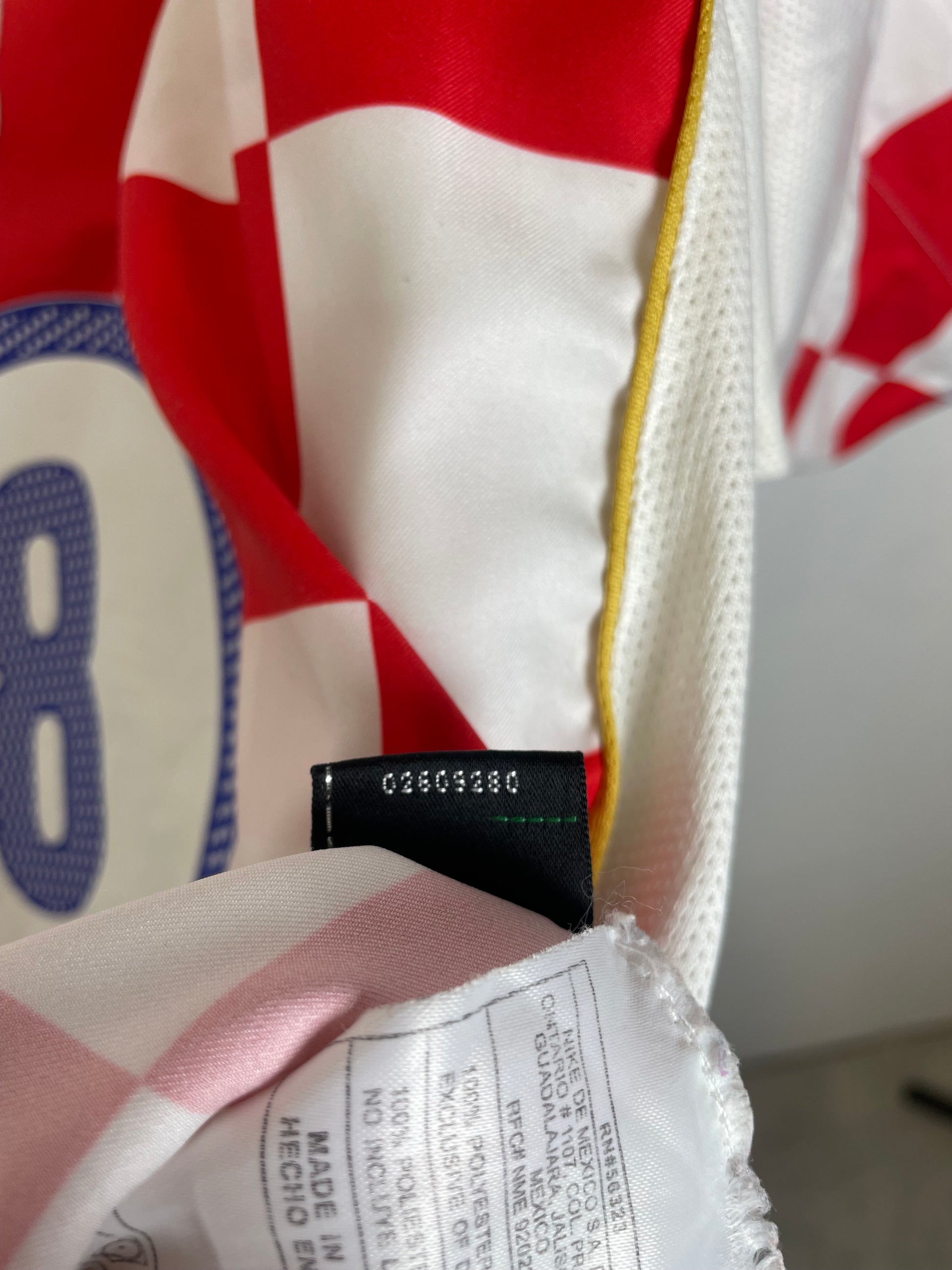 Close-up of a sports jersey with a brand label and text on a white background