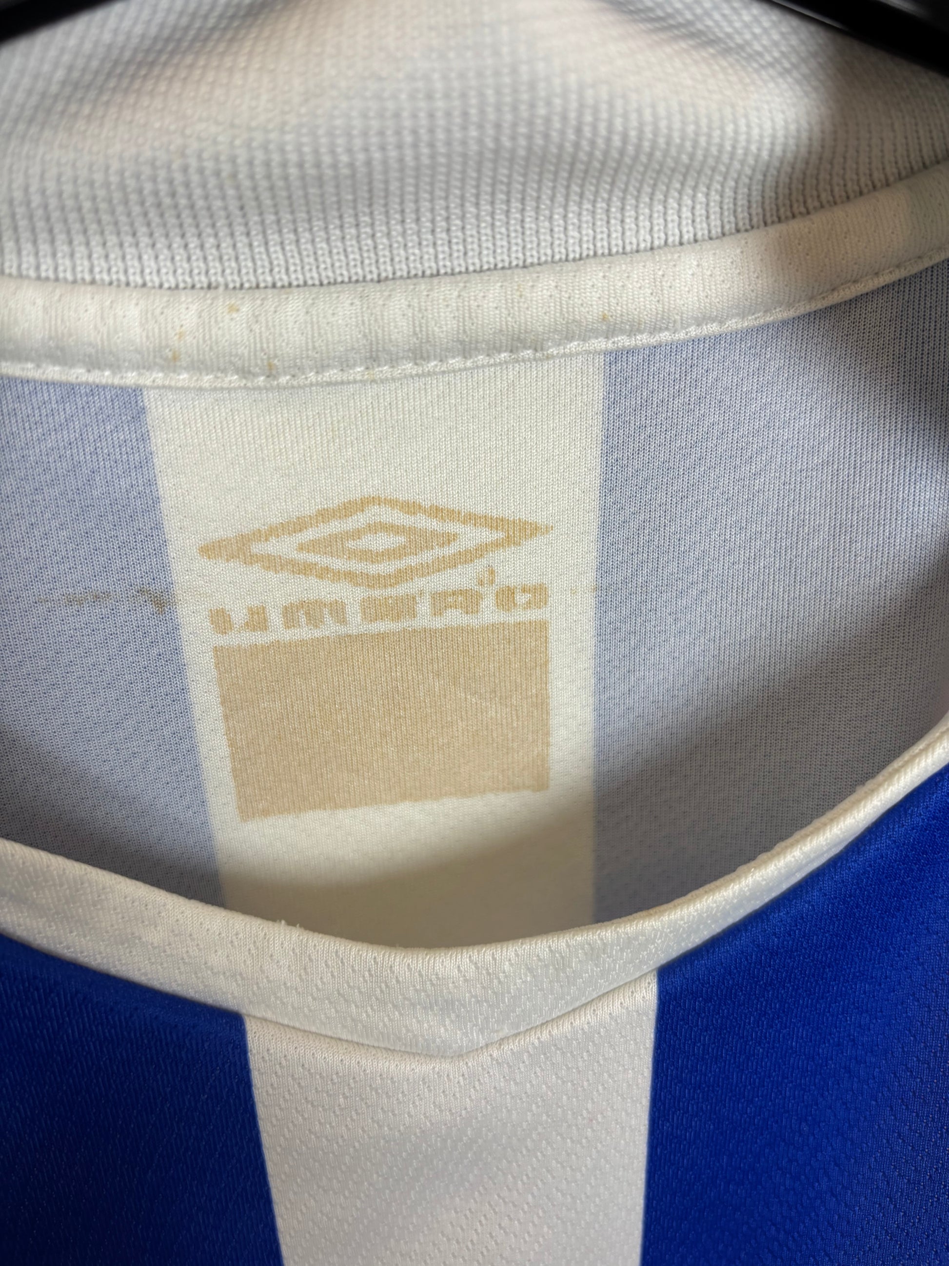 Close-up of a sports jersey with a brand logo on the collar.