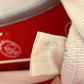 Close-up of Ajax club crest and sponsor logo on white Adidas home shirt 2021/22