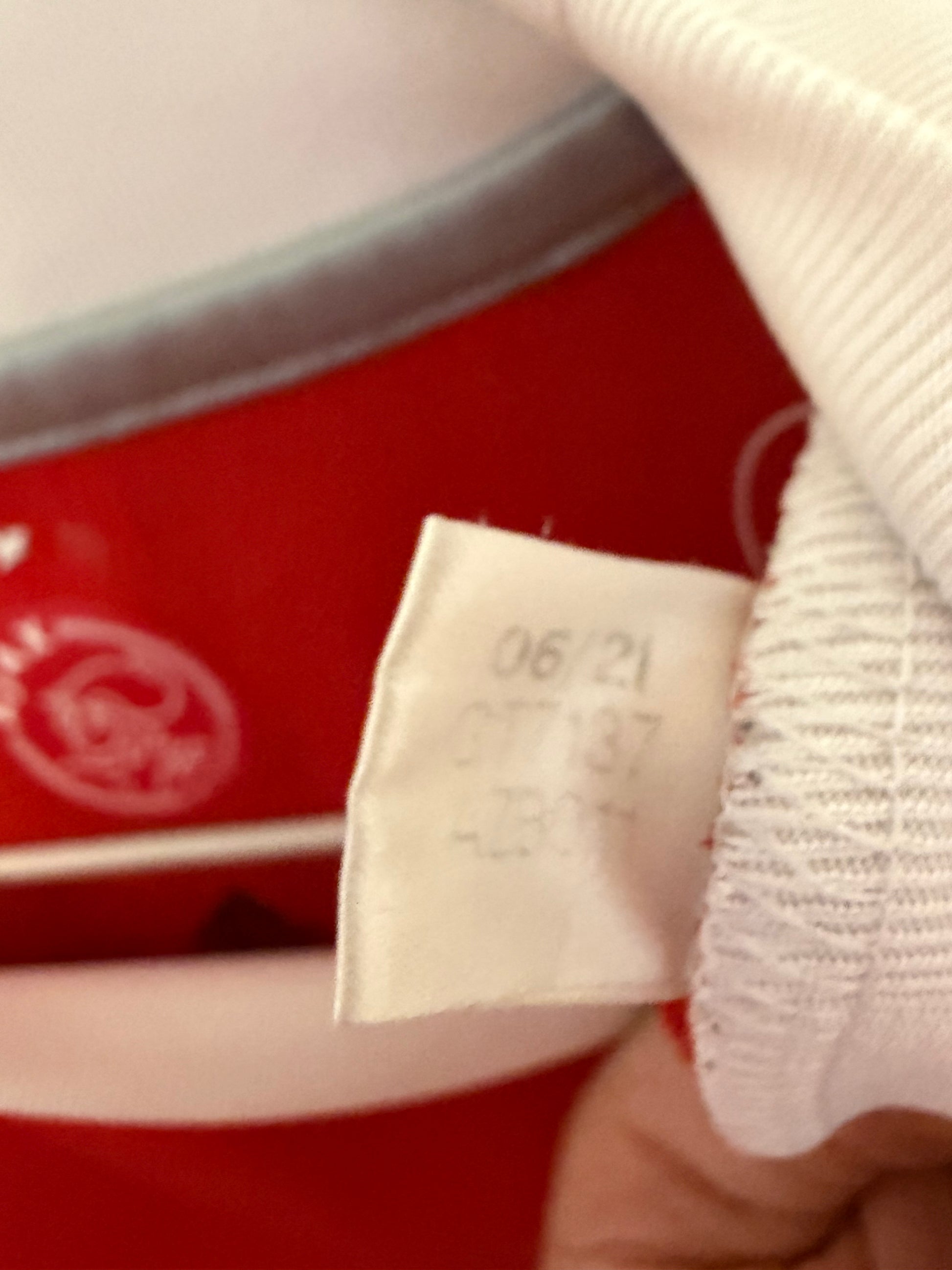 Close-up of Ajax club crest and sponsor logo on white Adidas home shirt 2021/22