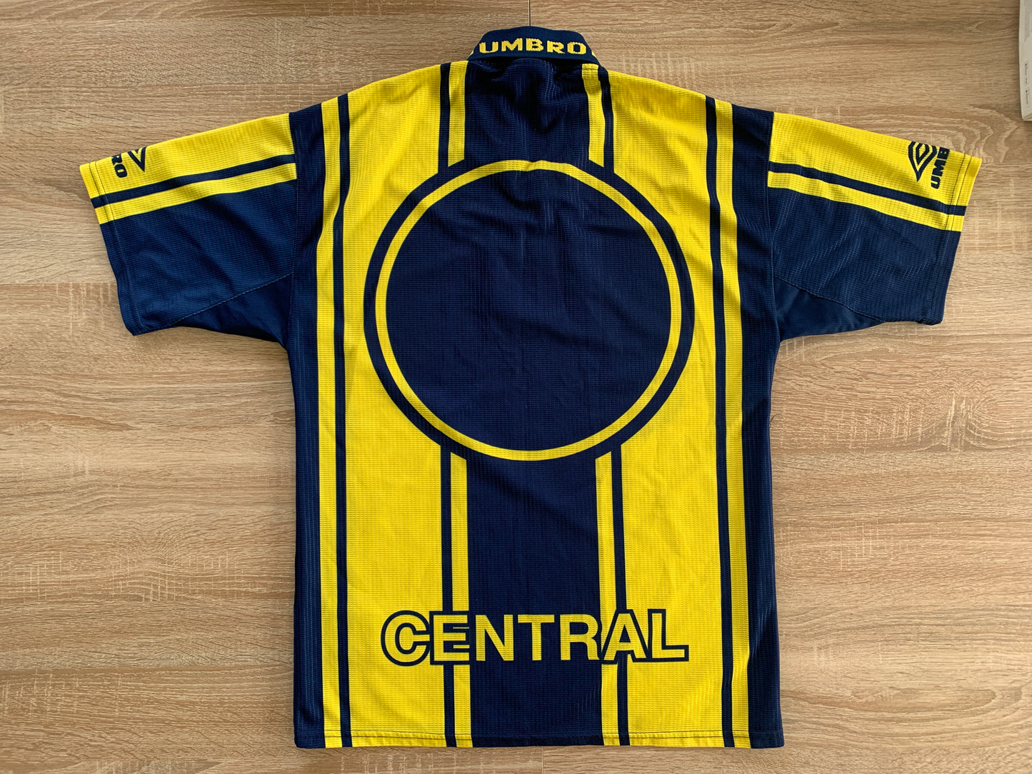 Rosario Central Home Shirt from 1998-1999: A classic representation of Rosario Central's home jersey during the 1998-1999 season. Featuring the club's emblem, it symbolizes the team's tradition and spirit on the field during that specific period.