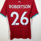 A red short-sleeve football jersey hanging on a black hanger against a light wall. The back of the shirt shows the name 'ROBERTSON' and the number '26' in white, with a small white crest near the collar and teal and white trim on the collar and sleeve cuffs.