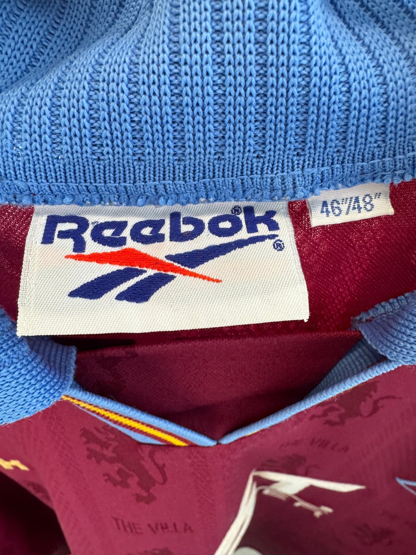 Close-up of the Aston Villa club crest on the original 95/97 claret and blue home shirt, shown in close detail
