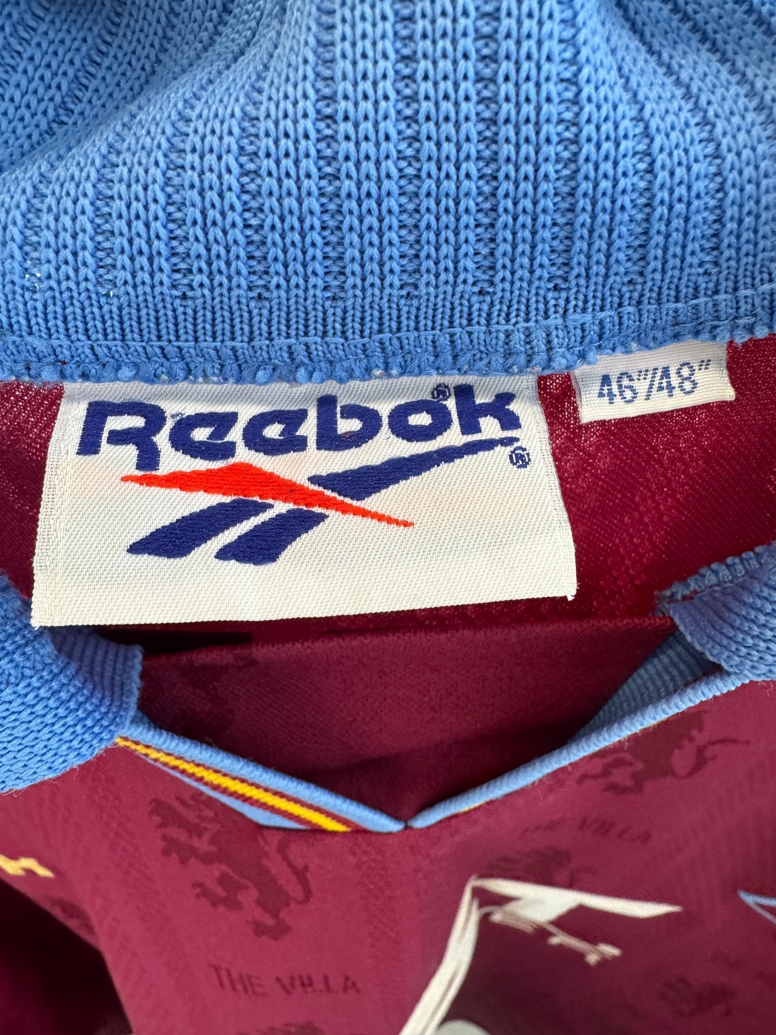 Close-up of the Aston Villa club crest on the original 95/97 claret and blue home shirt, shown in close detail
